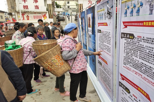 麻栗坡縣充分運用集鎮趕集日廣泛開展巡察宣傳動員、現場接訪等工作。圖為群眾在認真學習違紀違法典型案例。(謝繼文 攝).jpg 麻栗坡縣充分運用集鎮趕集日廣泛開展巡察宣傳動員、現場接訪等工作。圖為群眾在認真學習違紀違法典型案例。(謝繼文 攝).jpg